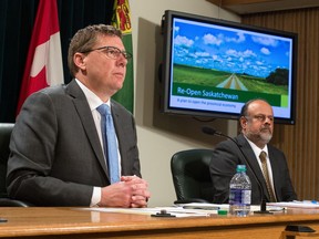 Saskatchewan Premier Scott Moe, left, communicates the government's plan to reopen the province's economy at a news conference held at the Saskatchewan Legislative Building in Regina, Saskatchewan on April 23, 2020. On the right is Saskatchewan's chief medical health officer Dr. Saqib Shahab.