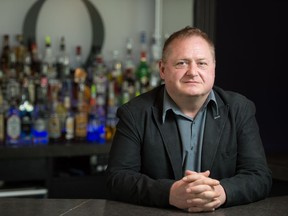 Cory Oxelgren, president of Gay & Lesbian Community of Regina, stands behind the bar at Q Nightclub on Broad Street in Regina, Saskatchewan on June 9, 2020. Gay & Lesbian Community of Regina owns the bar, which is in financial turmoil due to the COVID-19 pandemic.