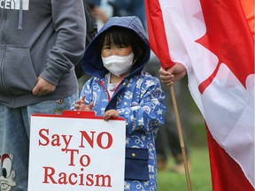 Anna Song holds a sign at a rally against racism towards the Chinese community during the COVID-19 pandemic. Photo taken in Saskatoon, SK on June 14, 2020.