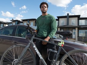Christian Mbanza stands with his bike in front of his car near his home in Regina, Saskatchewan on June 4, 2020. Christian Mbanza was racially profiled while going for a bike ride. A post was made to a community group on Facebook accusing him of stealing from cars in the neighbourhood. The car he was accused of stealing from was his own.