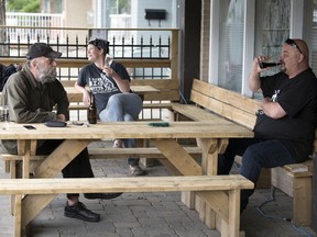 Wolfgang Pelzer, from left, Maureen Huot and Randall Mustatia enjoy a drink on the outdoor patio at Shannon's Pub and Grill in Regina on Monday, June 8, 2020.