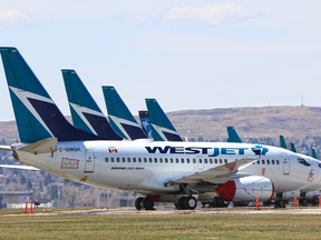 Parked WestJet Boeing 737 aircraft fill an unused runway at the Calgary International airport.