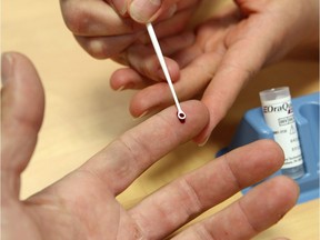 A nurse draws a drop of blood for hepatitis C testing.
