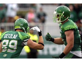 Chris Getzlaf (left) and Rob Bagg, shown celebrating a touchdown with the Saskatchewan Roughriders in 2014, are concerned about the 2020 season.