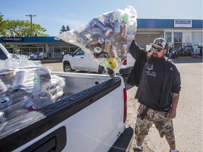 Johnathon Chetyrbuk unloaded a bag of cans at SARCAN. People lined up early with cans and bottles to recycle them at SARCAN, which opened on June 16, 2020 after a three-month shutdown due to COVID-19.