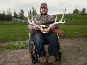 Bobbie Cherepuschak, a disabled hunter, sits with his unloaded 30-06 hunting rifle, unloaded 20 gauge over-under shotgun, and a set of deer antlers he harvested near his home in Lumsden, Saskatchewan on June 30, 2020. Certain allowances have been made by the provincial government to facilitate more accessible hunting for those with physical disabilities.