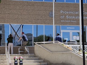Crews work on repairing a damaged window on the front of the Provincial Court of Saskatchewan on Lorne Street in Regina on Monday, July 6, 2020.