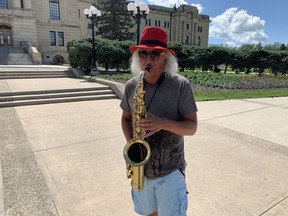 Keith Lee plays the saxophone outside the Legislative Building.