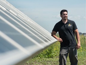 Dylan Toniello, co owner of Prairie Sun Solar, stands next to a ground mount solar array generating power for an acreage northwest of Regina, Saskatchewan on July 17, 2020.