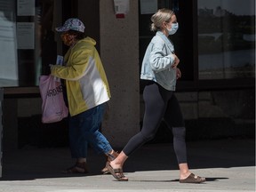 Two pedestrians wear masks in downtown Regina, Saskatchewan on July 28, 2020.