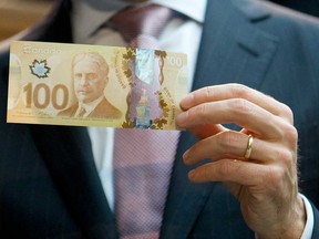 Then Governor of the Bank of Canada Mark Carney shows the new Canadian $100 bill in 2011. Now is a good time to revisit Carney’s 2012 denunciation of corporate savings as “dead money” that would be better spent than saved, writes Philip Cross.