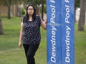 Miranda Hanus, a member of a group called Decolonizing Relations, stands next to a sign indicating she is standing in Dewdney Pool Park in Regina, Saskatchewan on July 24, 2020. Her group is renewing its campaign to see the City of Regina change the name of Dewdney Avenue and Dewdney Park and Pool to Buffalo Avenue and Buffalo Meadows and Pool.