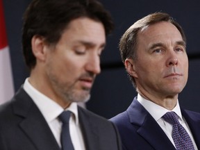 Bill Morneau, Canada's finance minister, right, listens while Justin Trudeau, Canada's prime minister, speaks during a news conference on the coronavirus in Ottawa, Ontario, Canada, on Wednesday, March 11, 2020.