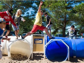A group of kids attending a Science Centre day camp play a round of "tube tag" on one of the play structures in front of the Saskatchewan Science Centre in 2018.