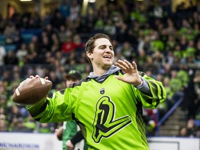 Saskatchewan Roughriders quarterback Cody Fajardo throws passes to fans on Jan. 18 during halftime of a National Lacrosse League game hosted by the Saskatchewan Rush.