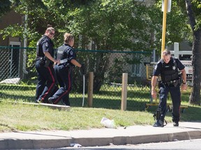 A police officer carries a sword from a home during a police operation on the 4700 block of 4th Avenue in Regina, Saskatchewan on August 6, 2020. The operation ended around 2 p.m., lasting some six hours.