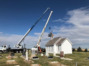 Dan Goud and Dave Delahey position a new bell tower on the roof of St. Columba Anglican Church on Aug. 13, 2020. After a wind storm blew off the church's bell tower, Dan Goud repaired the tower. The church, located near Moose Jaw, was built in 1898.
