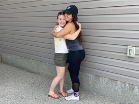 Amanda Ruller, right, hugs training partner Daphne Hodgson on Thursday. Ruller, an Olympic-style weightlifter, has quarantined with Hodgson throughout the COVID-19 pandemic period.