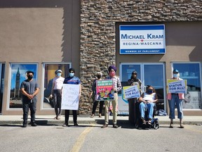 People rally outside of Regina Wascana MP Michael Kram's office, calling on the federal government to grant international students permanent residence in Canada.