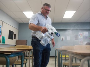 Henry Funke, operations manager for Regina Public Schools, demonstrates one of the Greco sprayers that will be used to disinfect surfaces of possible COVID-19 during a news conference held at Campbell Collegiate in Regina, Saskatchewan on August 25, 2020.