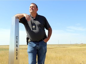 RCMP Sgt. Bob Thomas, who heads the Federal Serious and Organized Crime's Border Integrity unit in Saskatchewan, stands on a post that marks the border between Montana and Saskatchewan. Arthur White-Crummey/ Regina Leader-Post