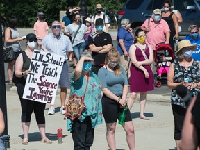 People attend a rally pertaining to concerns around the reopening of schools amid COVID-19, held at the Saskatchewan Legislative Building in Regina on Aug. 7, 2020.