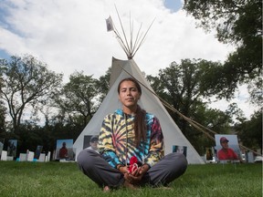 Tristen Durocher of Walking With Our Angels sits in front of the teepee where he is mounting a hunger strike in Wascana Park across from the Saskatchewan Legislative Building in Regina on Aug. 4, 2020.
