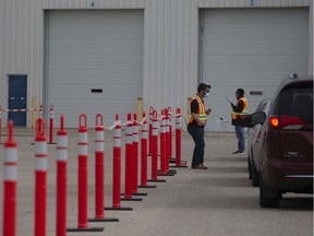 Healthcare workers wait outside for patients at Saskatoon's drive-through COVID-19 testing site.