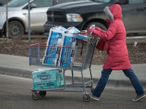 Amid concerns around COVID-19, a woman wheels a shopping cart containing toilet paper at Costco in Regina, Saskatchewan on Mar. 14, 2020.