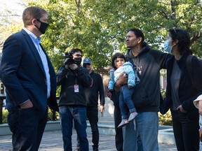 Prescott Demas, centre right, speaks with Conservative Party of Canada (CPC) MP Andrew Scheer, left, after Scheer spoke during a "virtual rally" broadcast over the internet, regarding the statue of John A. Macdonald in Victoria Park in Regina, Saskatchewan on Sept. 3, 2020. Demas spoke to Scheer about why people have called for the removal of the statue. BRANDON HARDER/ Regina Leader-Post