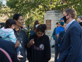 Prescott Demas, left, speaks with Conservative Party of Canada (CPC) MP Andrew Scheer, second from right, after Scheer spoke during a "virtual rally" broadcast over the internet, regarding the statue of John A. Macdonald in Victoria Park in Regina, on Sept. 3, 2020. Demas spoke to Scheer about why people have called for the removal of the statue.