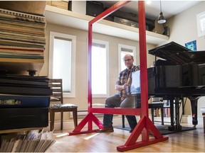 Music teacher Chris Kelly sits behind a large plexiglass shield he constructed to help make social distancing possible during lessons.