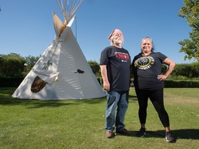 Don Wren, left, and Janna Pratt stand in front of a teepee set up in the park across from the Saskatchewan Legislative Building in Regina, Saskatchewan on Sept. 10, 2020. Both are members of the Unifor 1S Aboriginal and Workers of Colour Committee, which helped organize the set up of the teepee and accompanying learning opportunities provided to visitors.