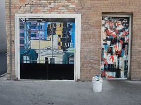 Downtown Regina Reflections by Pepito Escanlar, left, and Good to be Alive Today by Marilyn Nelson can be seen on a set of doors in the alley of Scarth Street in Regina, Saskatchewan on Sept. 11, 2020. The pieces are among a collection being exhibited across alley doors on Scarth Street.