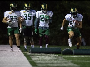 University of Regina Rams players Jayse Easton (33), Isaac Birdsell-Tyndale (35), Semba Mbasela (27) and Kyle Borsa (with football) participate in the team's first practice of the season Wednesday night at the U of R.