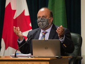 Saskatchewan's chief medical health officer Dr. Saqib Shahab, right, speaks to media regarding the COVID-19 pandemic during a news conference at the Saskatchewan Legislative Building in Regina, Saskatchewan on Sept. 17, 2020. Shahab is seen wearing a mask, which he briefly put on as he was speaking about mask usage.