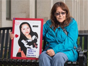 Dianne BigEagle holds a photo of her daughter Danita in front of Court of Queen's Bench in Regina, Saskatchewan on Sept. 18. 2020. Danita has been missing since 2007.