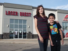 Kari-Lyn Galinec, left, and her son Ben Galinec stand in front of the Laser Quest location in Regina, Saskatchewan on Sept. 22, 2020. Laser Quest announced it will be closing it's Regina location. Kari-Lyn put a deposit down for her son's birthday party to be held at the location, and says now she hasn't heard back about a refund.