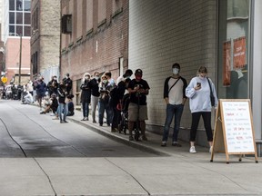 A long lineup of people wearing masks seeking a Covid 19 test forms on Shutter Street, Thursday September 10, 2020.