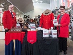 Author Pamela Cowan, right, and Dan Toppings, executive director of the RCMP Heritage Centre, stand near a display featuring Cowan's new book at the centre on Dewdney Avenue in Regina, Saskatchewan on Sept. 18, 2020.