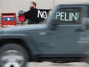 On the corner of Victoria Avenue and Albert Street on Oct. 12, 2018, vehicles rush past protesters with the Mother Earth Justice Advocates demonstrate against the Enbridge Line 3 replacement pipeline. The line runs from Hardisty, Alta., to Wisconsin, and runs several kilometres south of Regina and in the White City vicinity. BRANDON HARDER/ Regina Leader-Post