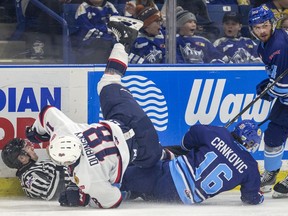 Saskatoon Blades forward Kyle Crnkovic and Regina Pats forward Cole Dubinsky hit the ice and take down a linesmen during a March 6 game at SaskTel Centre. The WHL hopes to launch its new season in January.