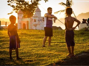 Jon Jon Rivero, centre, demonstrates a martial arts move to two children during one of his trips to the Philippines while filming his documentary Balikbayan: From Victims to Survivors. The documentary premieres at the Edmonton International Film Festival on Oct. 7, 2020.