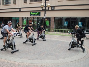 A workout class led by  Carla Loiselle of Evolution Fitness, right, takes place on Scarth Street in Regina, Saskatchewan on Oct. 6, 2020. The class acts as a way to allow people to exercise outdoors during the COVID-19 pandemic.