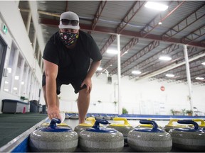 AJ Scott, general manager of the Highland Curling Club, demonstrates the wiping down of a rock at the club on Oct. 7.