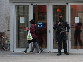 A police officer stands guard at the 11th Avenue entrance to the Cornwall Centre after the Regina Police Service received information about a potential bomb threat on Oct. 7, 2020.