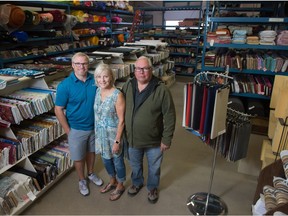 From left, Jered Kirkland with his mom Erica Kirkland and father Russ Kirkland stand in the back of Globe Fabrics on Park Street in Regina, Saskatchewan on Oct. 10, 2020. The family is planning to shut down their fabric business at the end of October after roughly 50 years of operation.