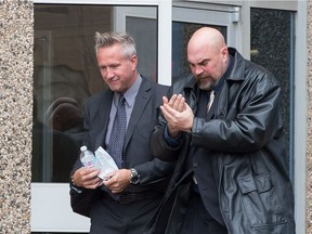 Regina Police Service Const. Roger Wiebe, left, leaves Regina Provincial Court, where he is on trial for a charge of assault.
