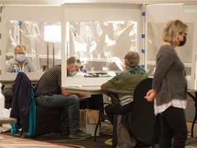 Elections workers can be seen in one of the rooms where the mail-in ballots for the provincial election are being counted at the Delta hotel in Regina on Oct. 28, 2020.