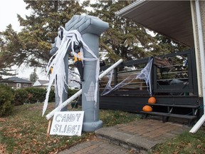 A Halloween display is seen on the front yard of a home on Broadway Avenue in Regina, Saskatchewan on Oct. 28, 2020. A "candy slide" made of PVC pipe is part of the display, and is meant to allow the home's residents to pass candy to trick-or-treaters while maintaining social distance.